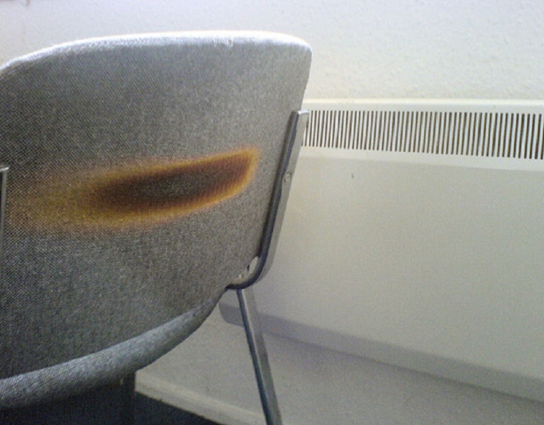 fabric covered chair with scorch marks to backrest from being against a convection heater